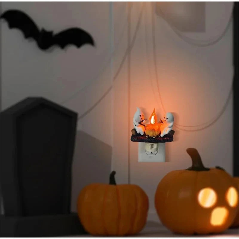 A glowing orange pumpkin with a small firelight decoration and a bat silhouette on a white wall.