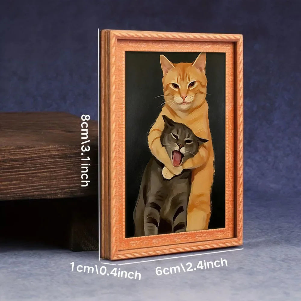 A framed picture of an orange tabby cat hugging a black cat, displayed in a wooden frame.