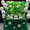 A green balloon arch decorated with white and lime green latex football balloons on a table.