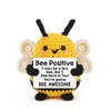 Handmade crochet bee baseball bat doll with a positivity card featuring the text Bee Positive