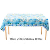 A light blue tablecloth decorated with cartoon elephants and blue clouds for a party setting.
