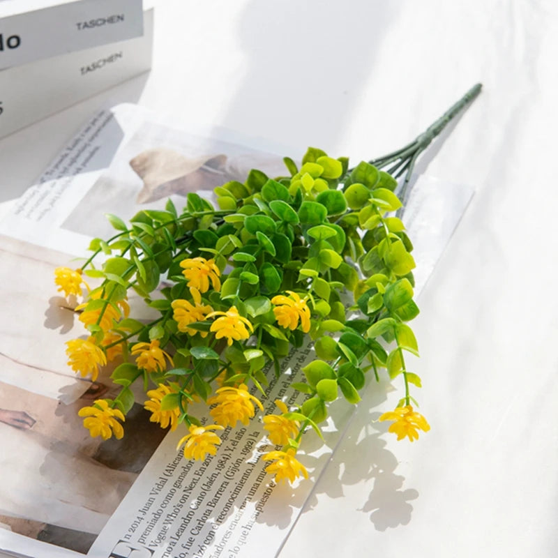 A branch of artificial eucalyptus with seven stems, featuring bright green faux leaves and yellow flowers.