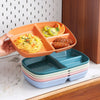 An orange portion control plate is shown filled with fruit and a savory dish, next to a stack of similar blue and green plate