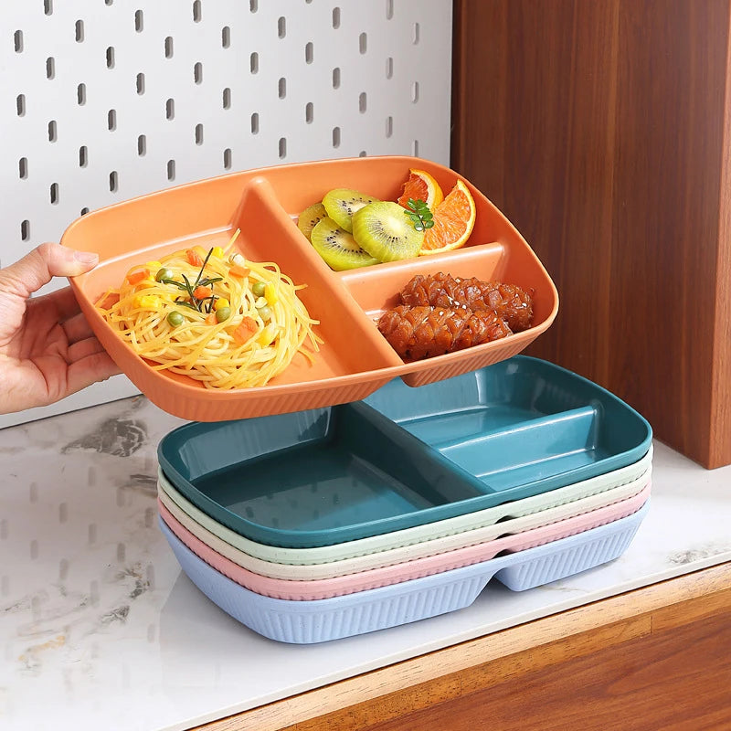 An orange portion control plate is shown filled with fruit and a savory dish, next to a stack of similar blue and green plate