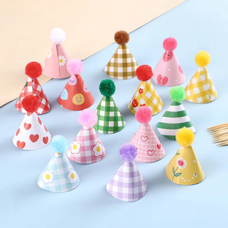 A collection of colorful mini birthday cake toppers featuring various patterns and pink, yellow, and green colors.