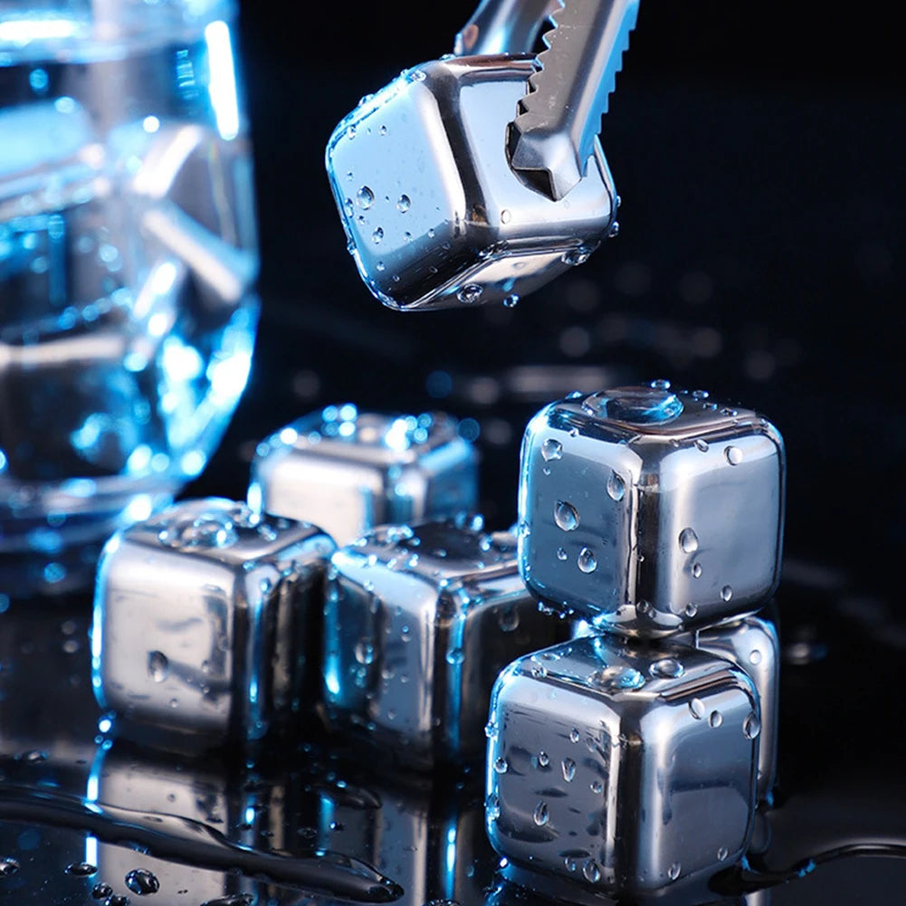 Close-up of reusable stainless steel ice cubes dripping water on a dark surface.
