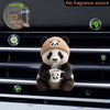A cute panda bear plush toy holding a teacup is displayed on a black car vent clip.