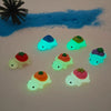 A collection of glow-in-the-dark fruit turtle resin charms in various colors scattered on a white surface.