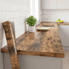 A wooden countertop with a faucet and a potted plant in a modern kitchen setting.