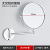 A round, silver-framed folding double-sided wall mirror with telescopic arms mounted on a light gray wall.