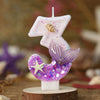 Pink and purple mermaid tail birthday candles decorated with glitter and starfish