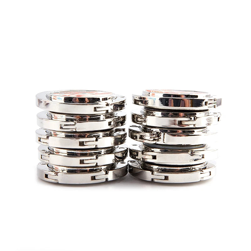 A stack of silver foldable handbag hooks for tables and desks.