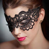 A close-up of a woman wearing a black lace floral eye mask for masquerade or cosplay.