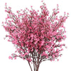 A dense branch of pink cherry blossoms and white gypsophila artificial flowers.