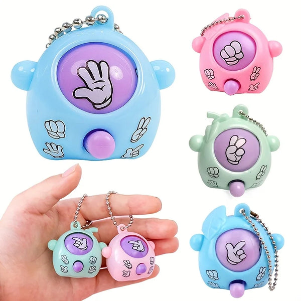 A hand holds three mini Rock-Paper-Scissors themed silicone keychains in blue, pink, and green.