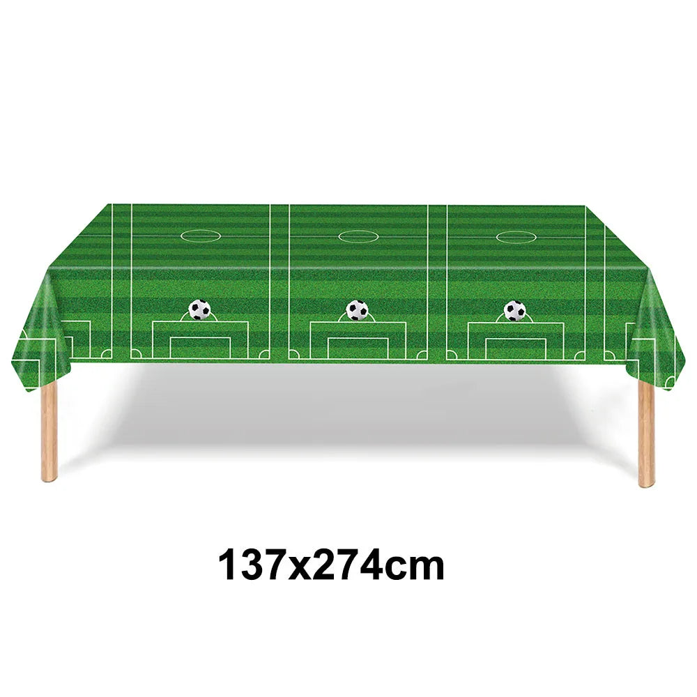Green soccer field themed table cloth with decorative soccer balls for a birthday party