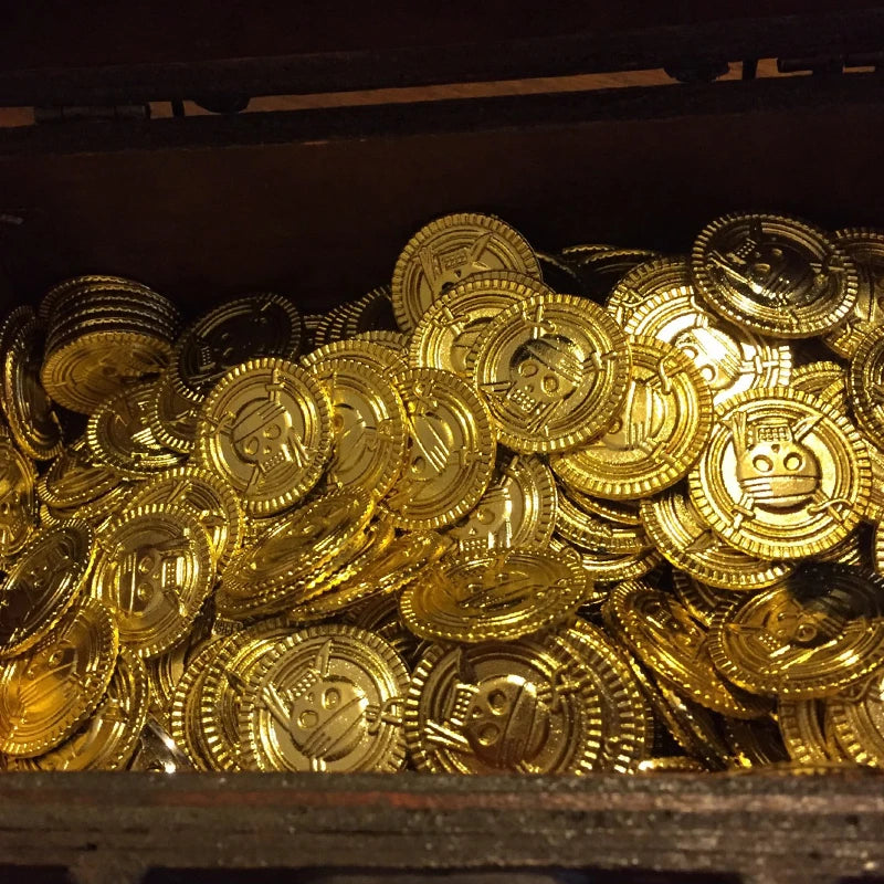 A close-up view of a large pile of gold pirate coins, likely party favors.