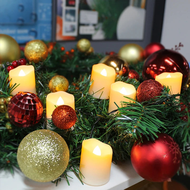 A festive wreath decorated with gold and red spherical ornaments and glowing LED tea light candles.