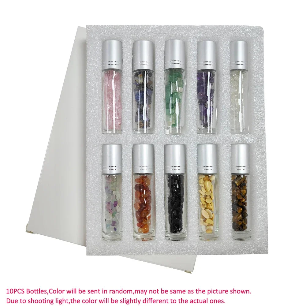 A set of ten small glass bottles containing various colored semi-precious stone roller balls for aromatherapy or massage.