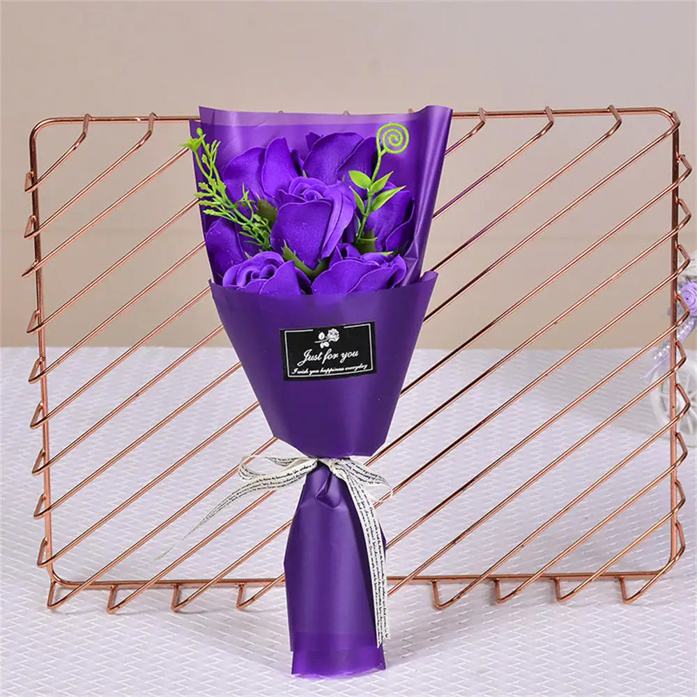 A purple handcrafted soap rose bouquet displayed in a glass vase on a copper wire rack.