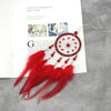 A red dream catcher pendant featuring a crystal mirror and long feathers displayed on a white background.