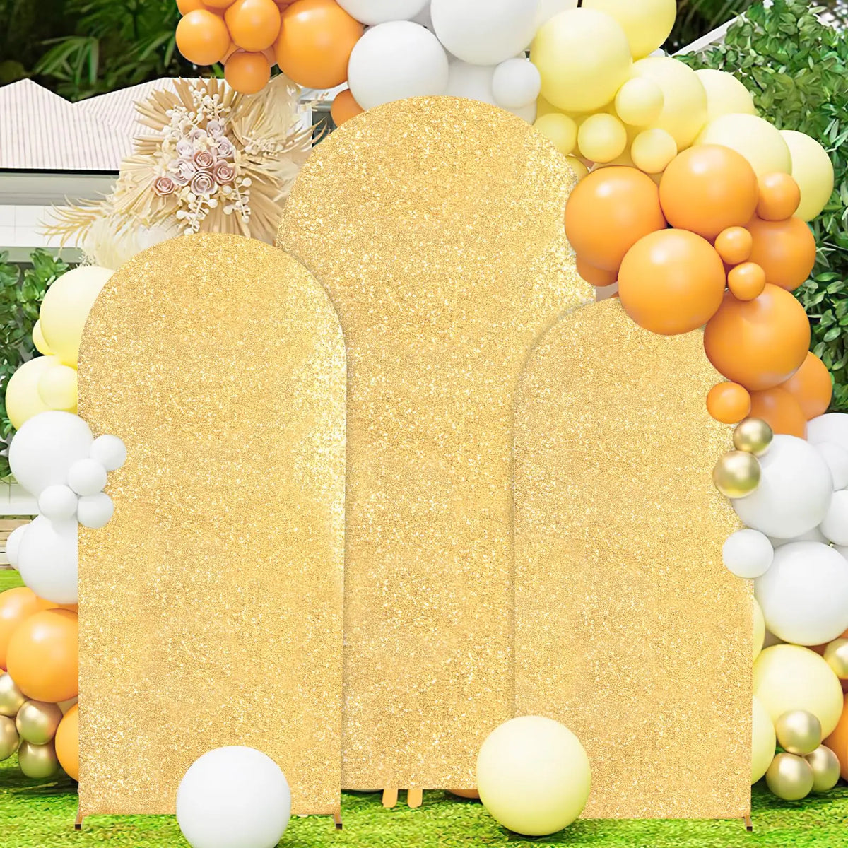 A golden sequin arch backdrop decorated with various colored balloons for a wedding or party.