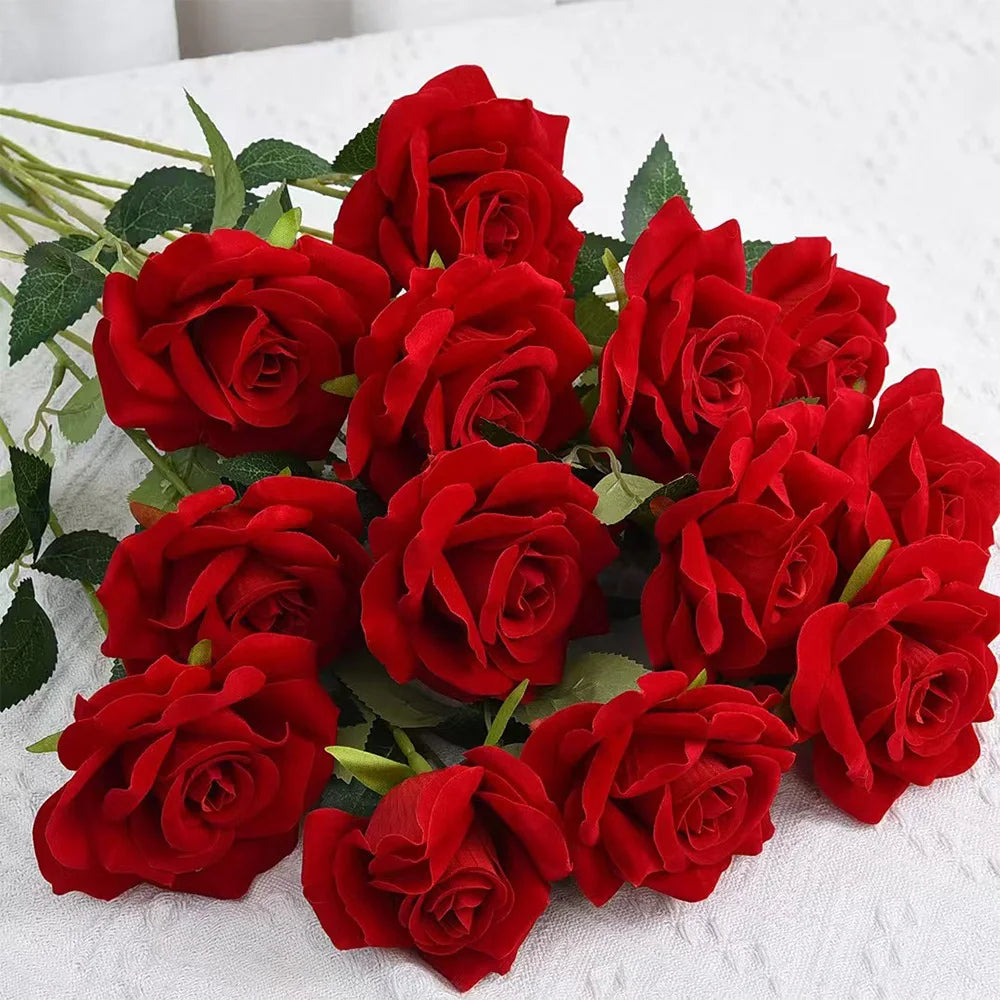 A bouquet of vibrant red artificial roses arranged on a white surface.