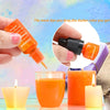 A hand is shown dropping orange liquid dye into a glass, with finished orange and orange-colored candles nearby.