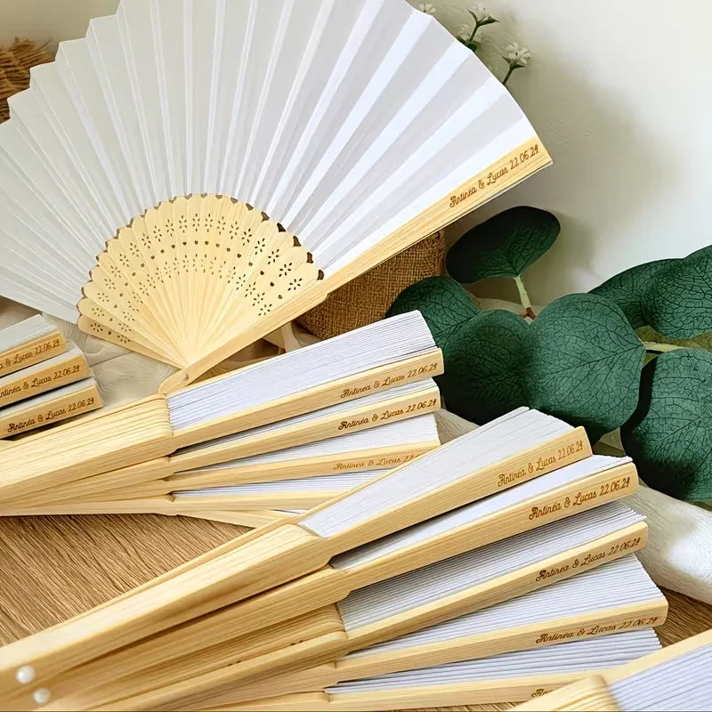 A stack of light wood bamboo folding fans with white paper for calligraphy and decor