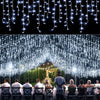 String lights hanging in a curtain formation creating a sparkling backdrop for an outdoor event or Christmas decoration