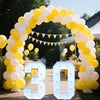 A large marquee sign shaped like the number 30 made of light-up acrylic letters surrounded by yellow and white balloons.