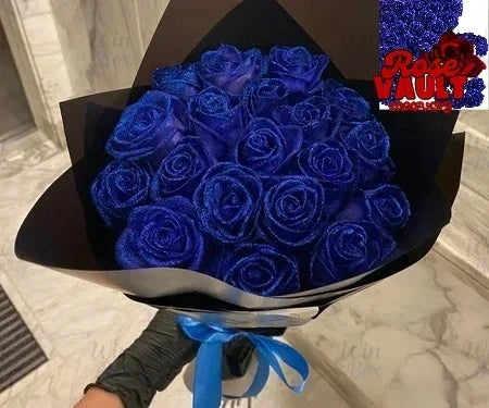 A bouquet of deep blue glitter artificial roses in a black box with a purple label