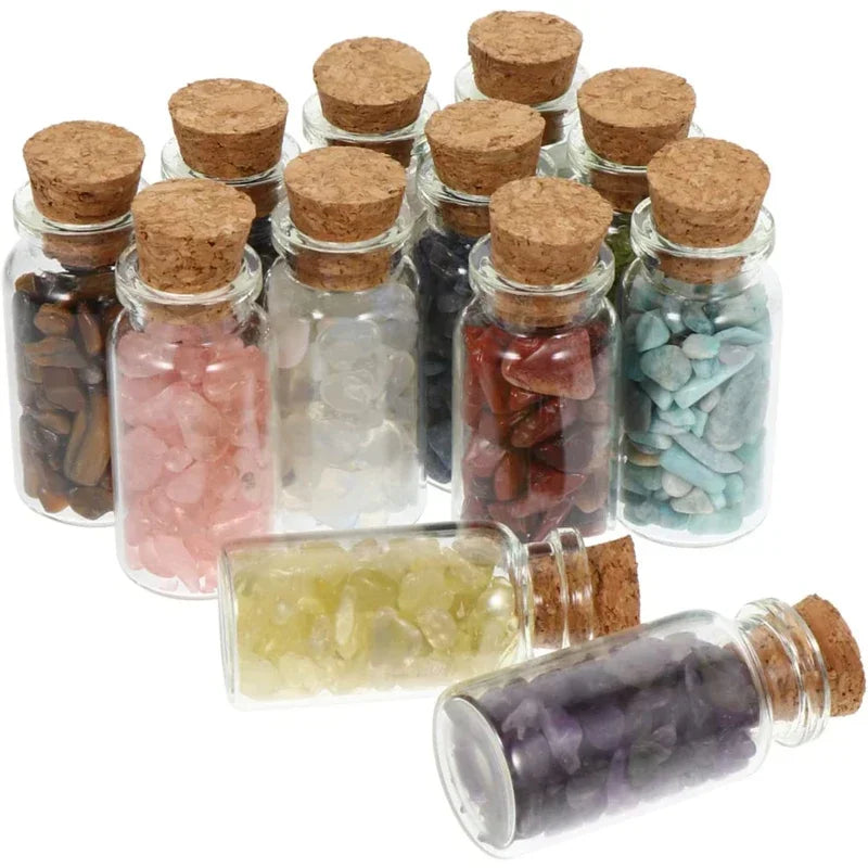 A collection of glass jars with cork stoppers filled with various colored crystals and stones for DIY decor