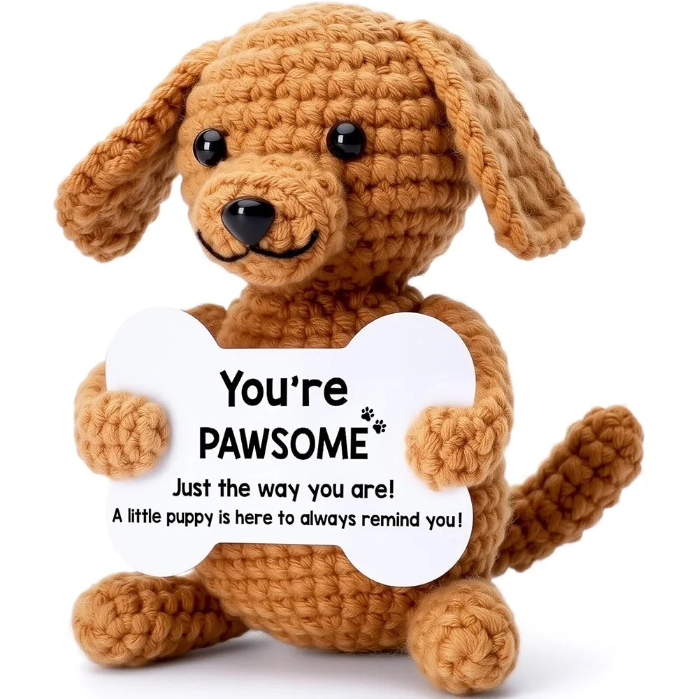 Handmade crochet puppy doll in brown yarn holding a white card that says You're pawsome