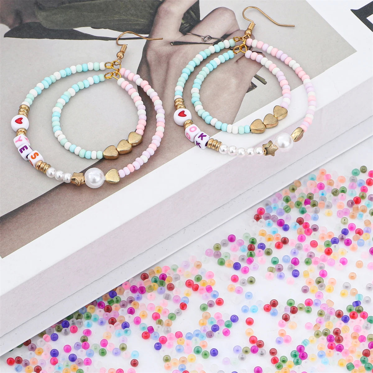 Gold and silver hoop earrings with beaded chains and colorful glass rice beads