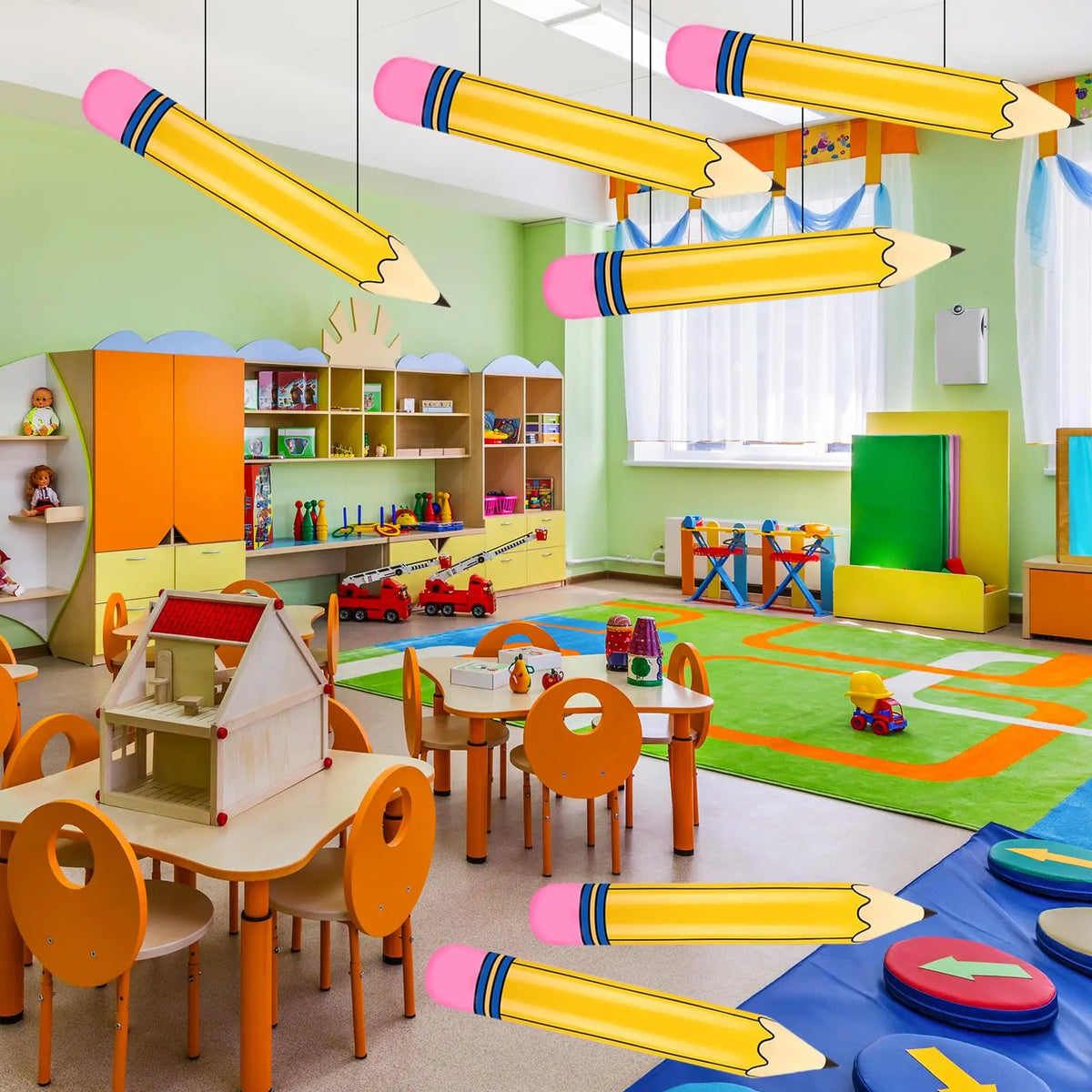 Colección de globos de lápiz inflables gigantes en amarillo y rosa decorando un aula o área de juegos.