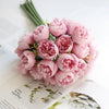 A bouquet of artificial pink peony silk flowers arranged on a white background.