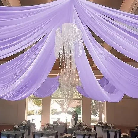 Purple sheer chiffon curtains draped overhead with a chandelier in an indoor event setting.