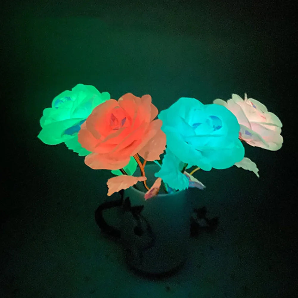 A bouquet of glowing foil roses in shades of green, orange, blue, and white, illuminated against a dark background.