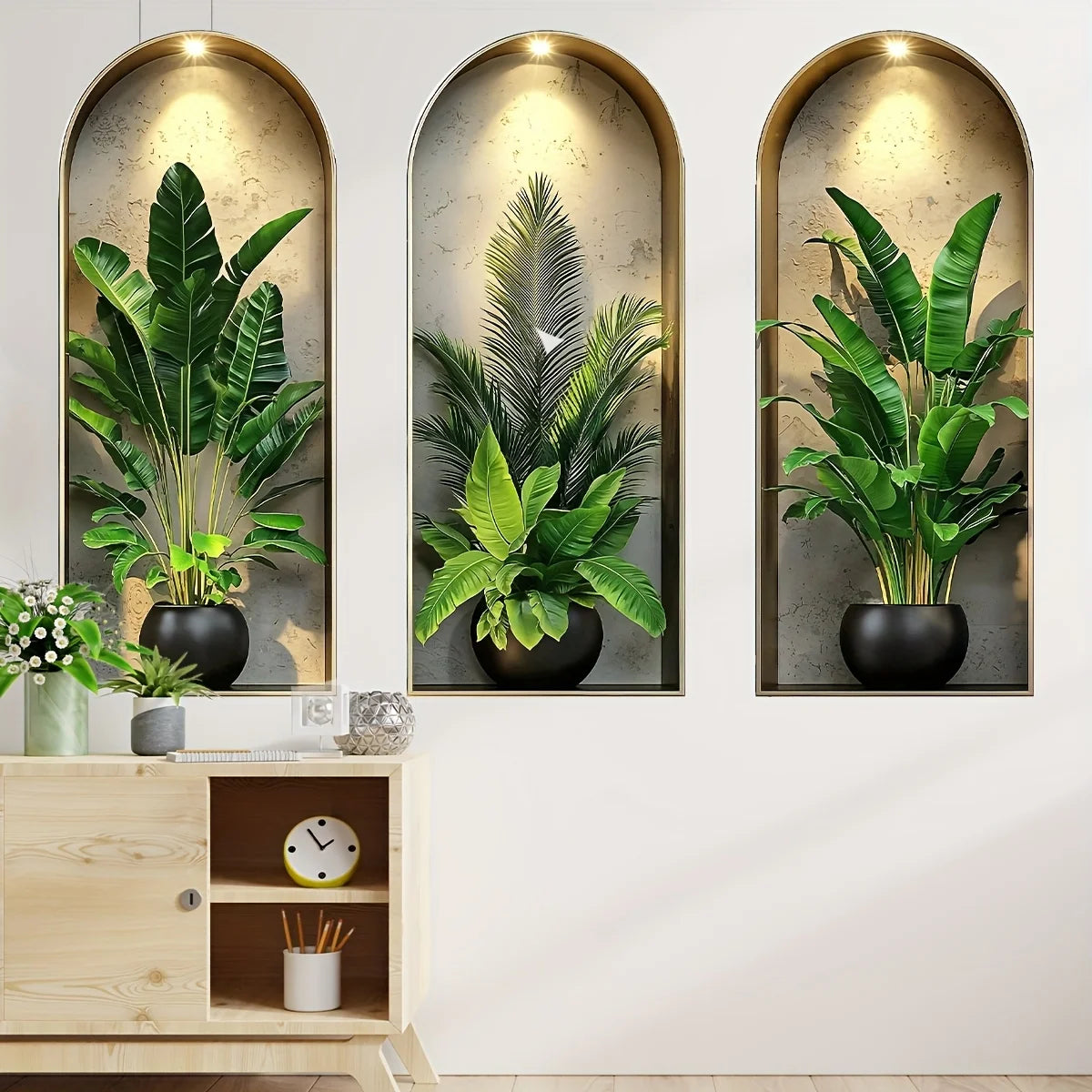 Three framed botanical prints featuring lush green potted plants and vines on a white wall.