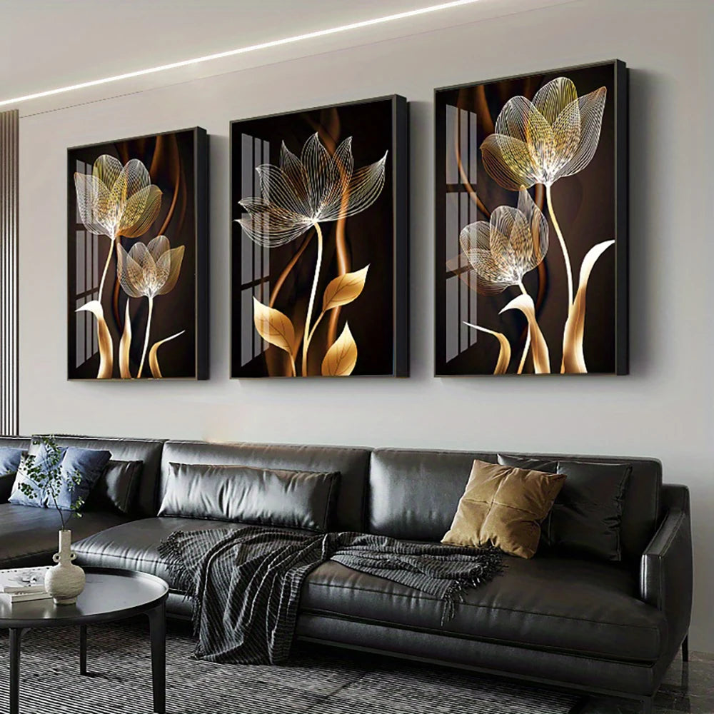 A set of three abstract floral canvas wall art pieces featuring golden and dark tones displayed above a modern sofa.