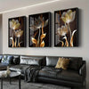 A set of three abstract floral canvas wall art pieces featuring golden and dark tones displayed on a modern living room wall.