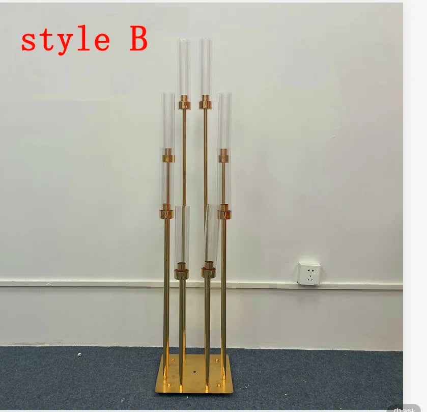 A set of eight gold metal candle holders or candelabra displayed against a white wall.
