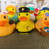 A collection of yellow rubber duck bath toys, including one with a black hat and another with colorful accents.
