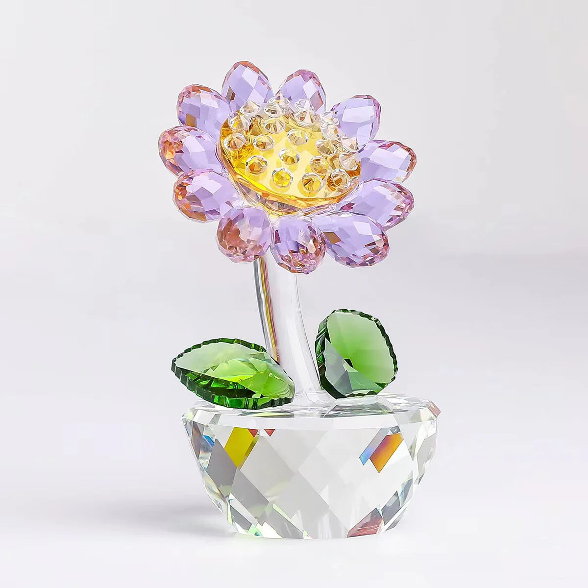 Handcrafted glass crystal sunflower figurine with a yellow center and purple petals on a clear base
