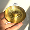 A round brass incense stick holder plate with a decorative pattern and a 2cm height measurement.