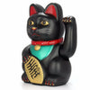 A black figurine of a cat with red ears, wearing a red collar and gold accents.