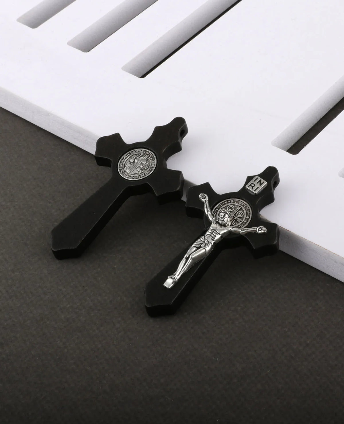 A set of black wooden crucifix pendants featuring embossed religious symbols.