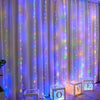 Purple and pink LED curtain fairy lights illuminating a sheer fabric backdrop.