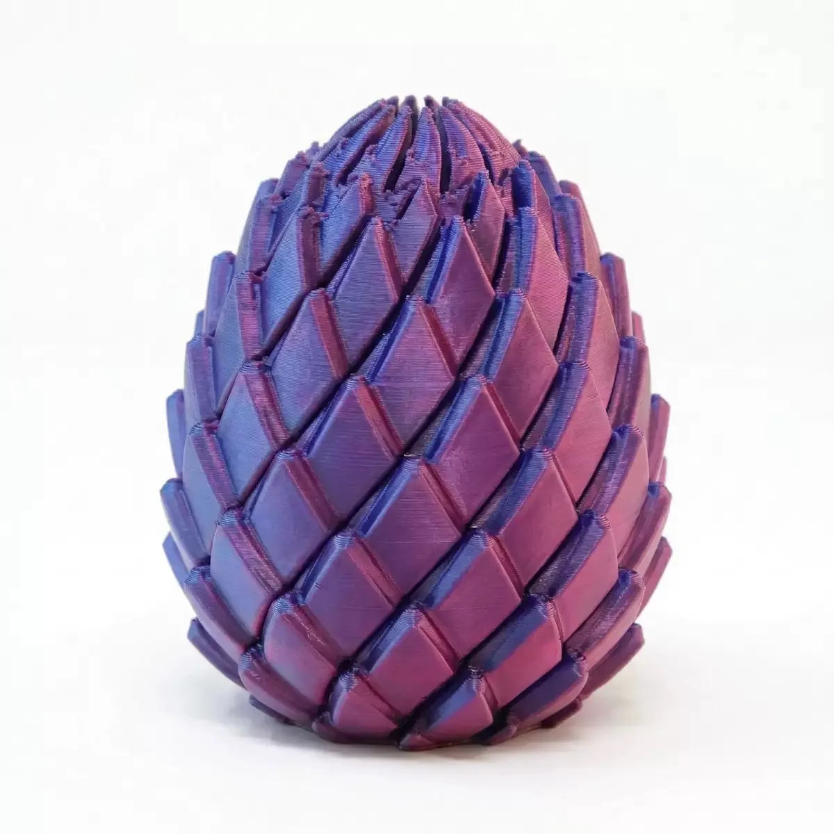 A purple, textured dragon egg stress relief toy with a pyramidal shape.